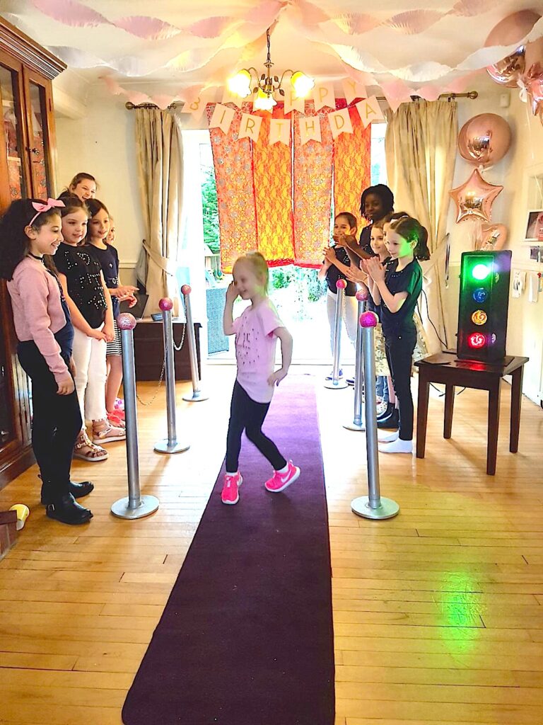 Friends cheering and clapping their friend walking down a catwalk runway in her t-shirt design.