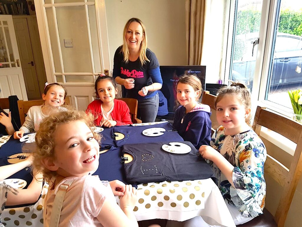 Girls sat around a table designing their fashion diva t-shirts.