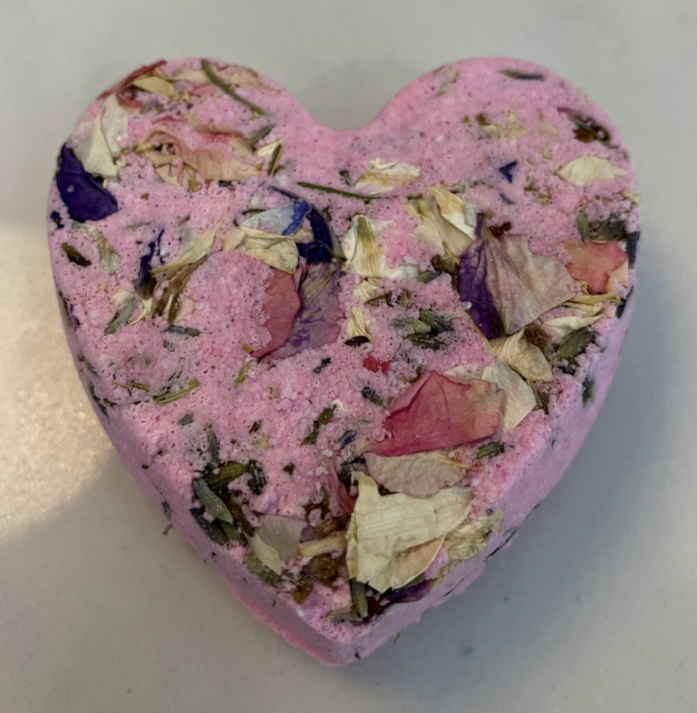 Pink heart shaped bath bomb with dried flowers