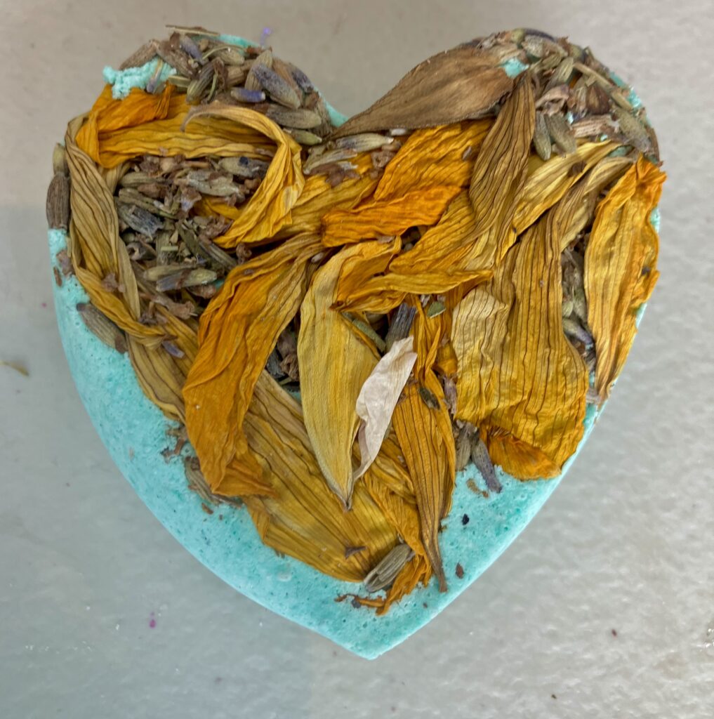 blue flower shaped bath- bomb with dried lavender and sunflower leaves