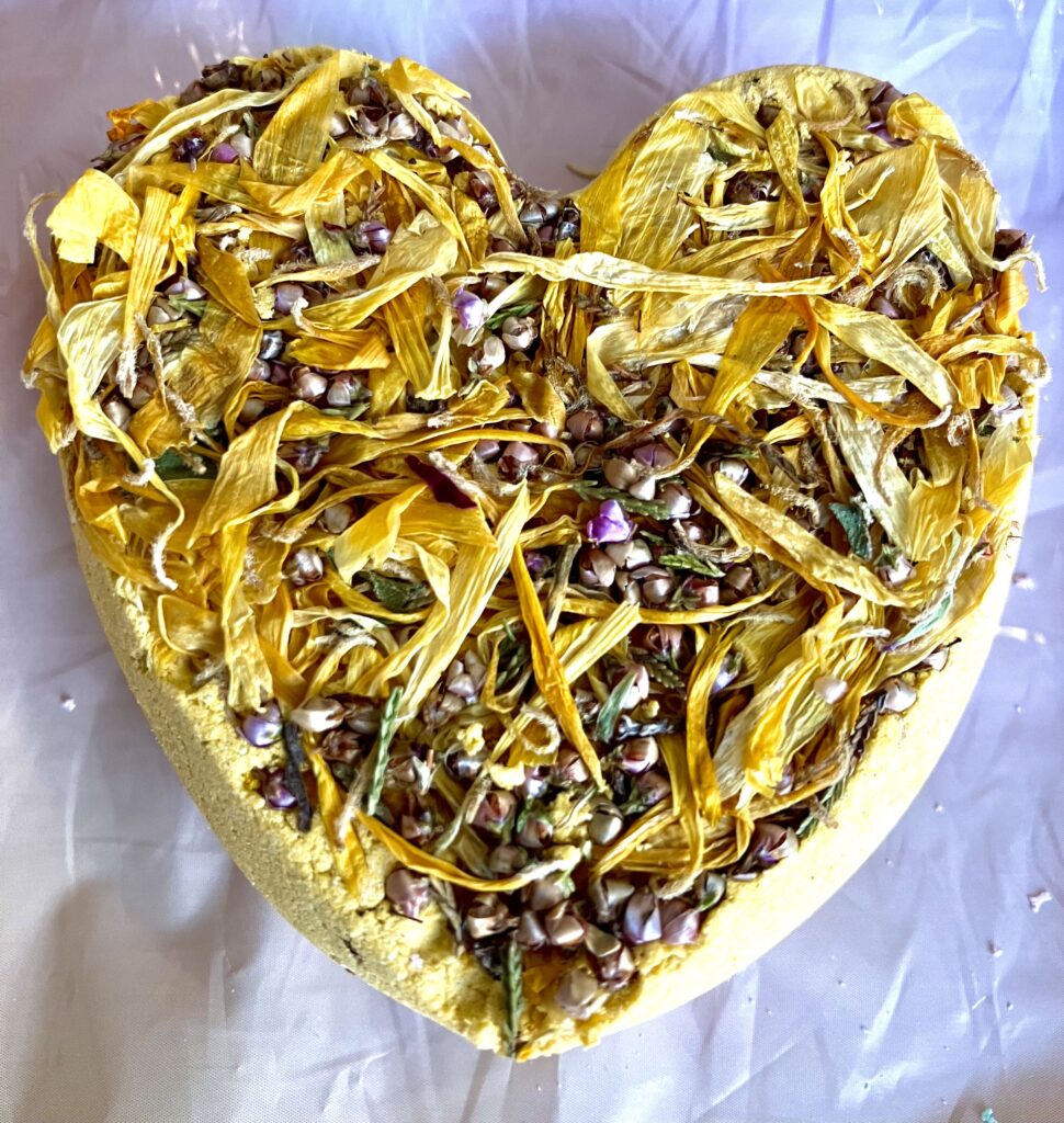 yellow coloured heart shaped bath-bomb with dried marigold petals and lavender