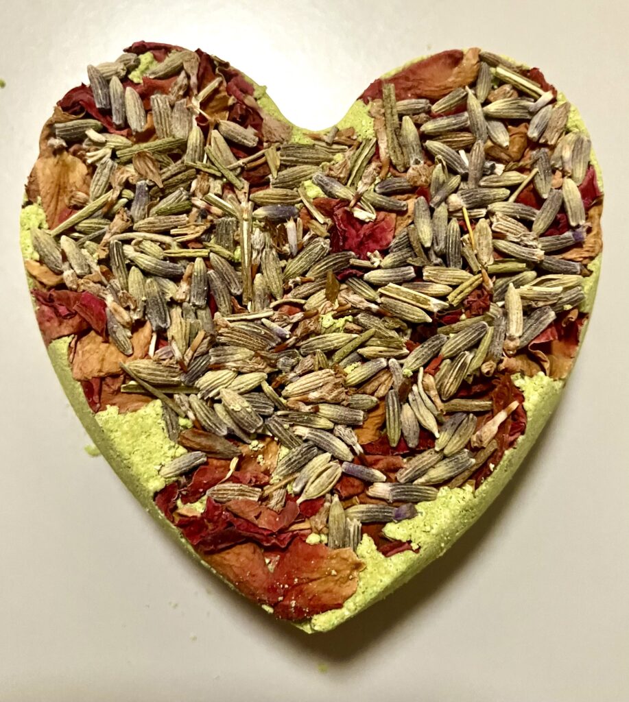 Lime coloured heart shaped bath-bomb with dried rose petals and lavender