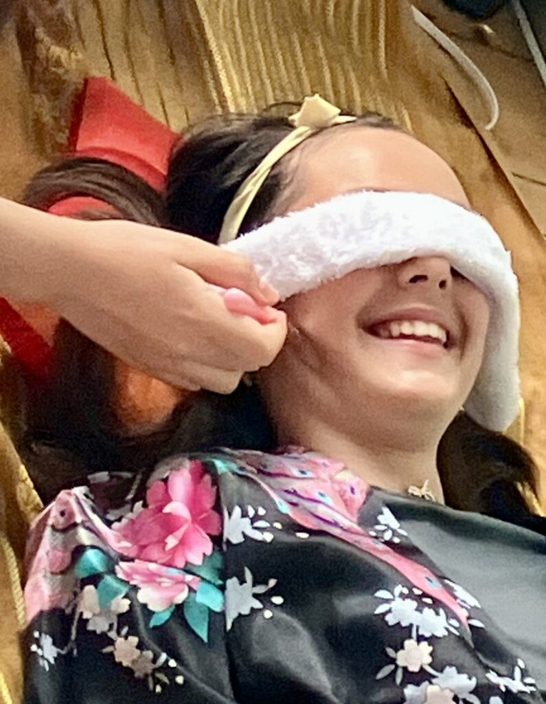 Spa party girl having face mask applied