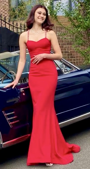 Girl in a beautiful full length red dress, ready for the prom.