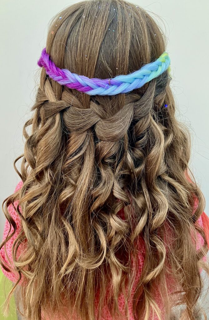Back of a girls head showing off a waterfall braid & a coloured extention.
