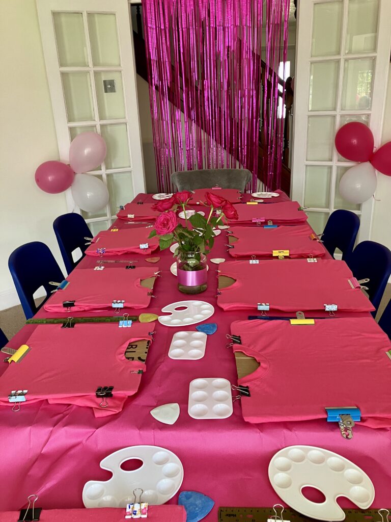 Eight Pink T- shirts laid out on a table ready for the fashion diva party to start.