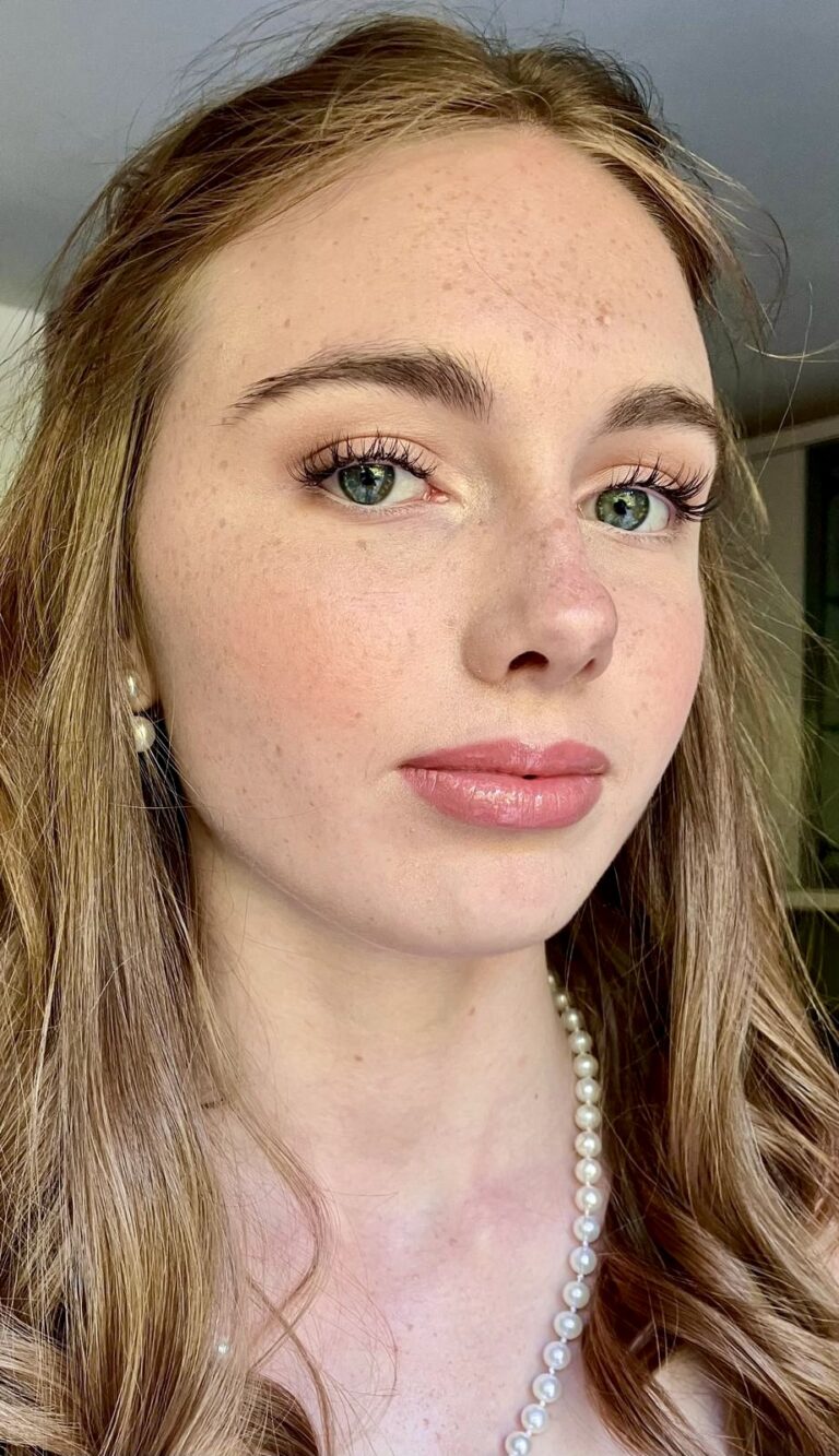 girl posing for a picture having had her prom hair and make up done.